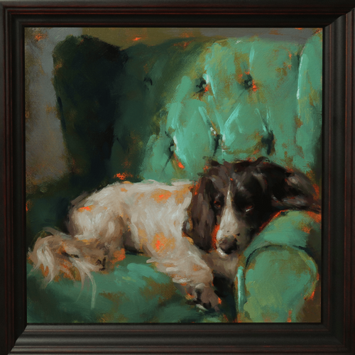 A framed oil painting depicting a black and white dog resting on a green armchair, enclosed in a dark brown wooden frame.
