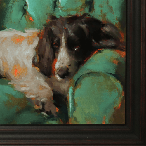 A close-up of a framed painting depicting a black and white dog resting on a green couch, with visible brushstrokes and a dark wood frame.
