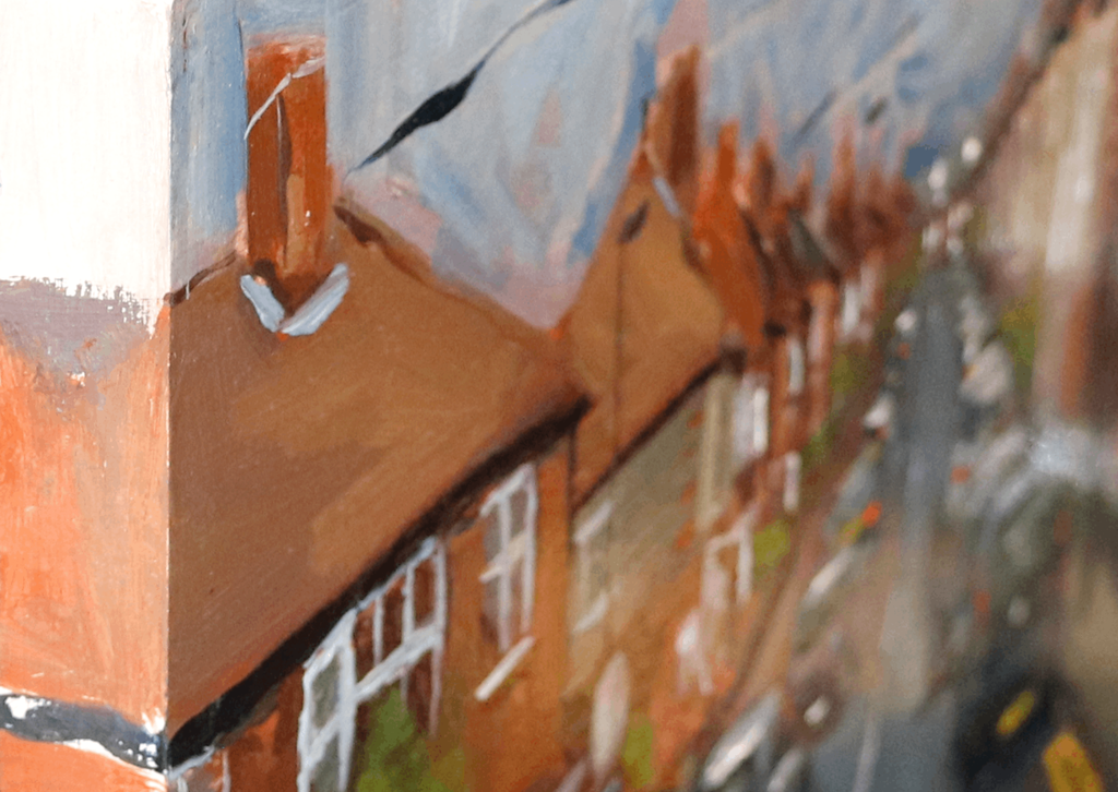 Close-up of an oil painting depicting a street scene with terracotta-colored houses, white window frames, a blue-gray sky, and a blurred roadway.