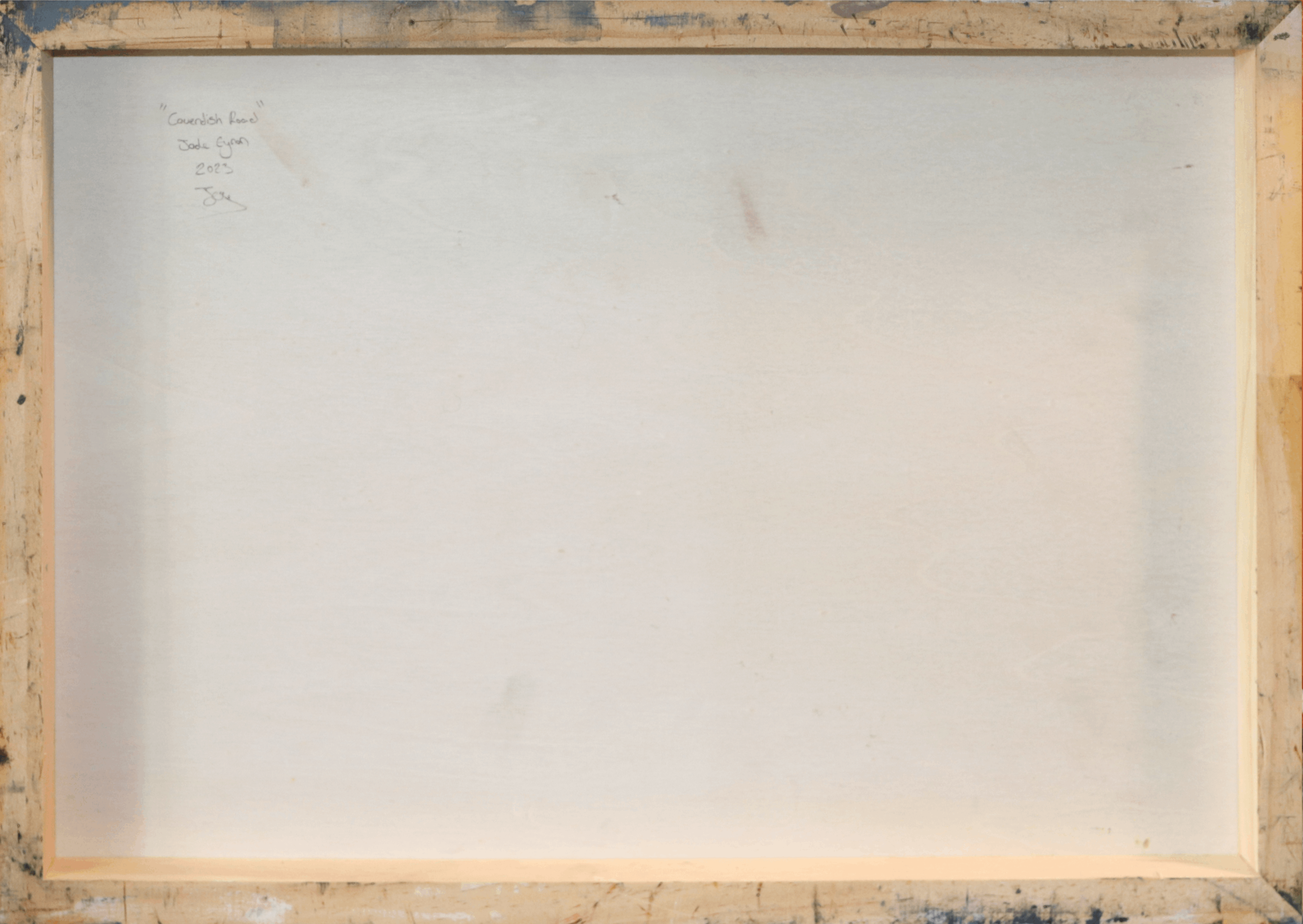 The back side of a square canvas print, showing a light beige painted surface inside a rustic wooden frame with visible texture and paint drips.