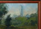 A framed landscape oil painting featuring a hazy city skyline with a prominent blue-gray skyscraper, surrounded by green trees and foliage in the foreground, enclosed in a warm brown wooden frame.