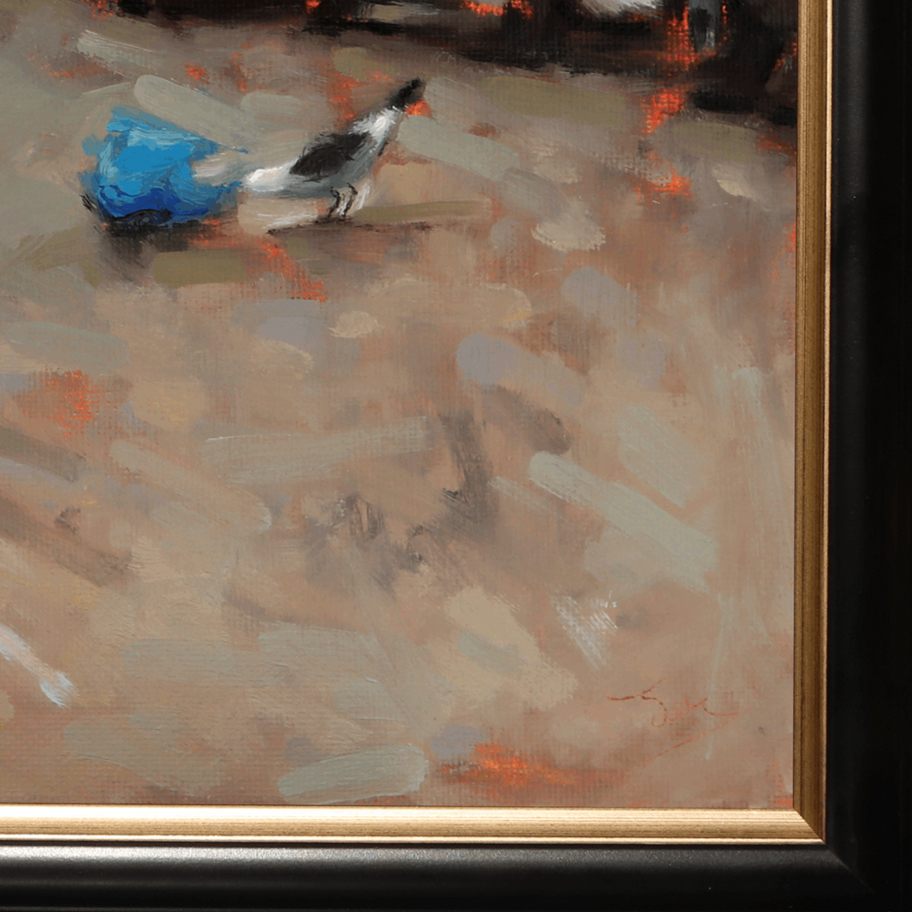 Close-up of a framed painting showing an abstract scene with a small bird and a bright blue shape against a warm beige and brown background, with visible gold and black frame details.