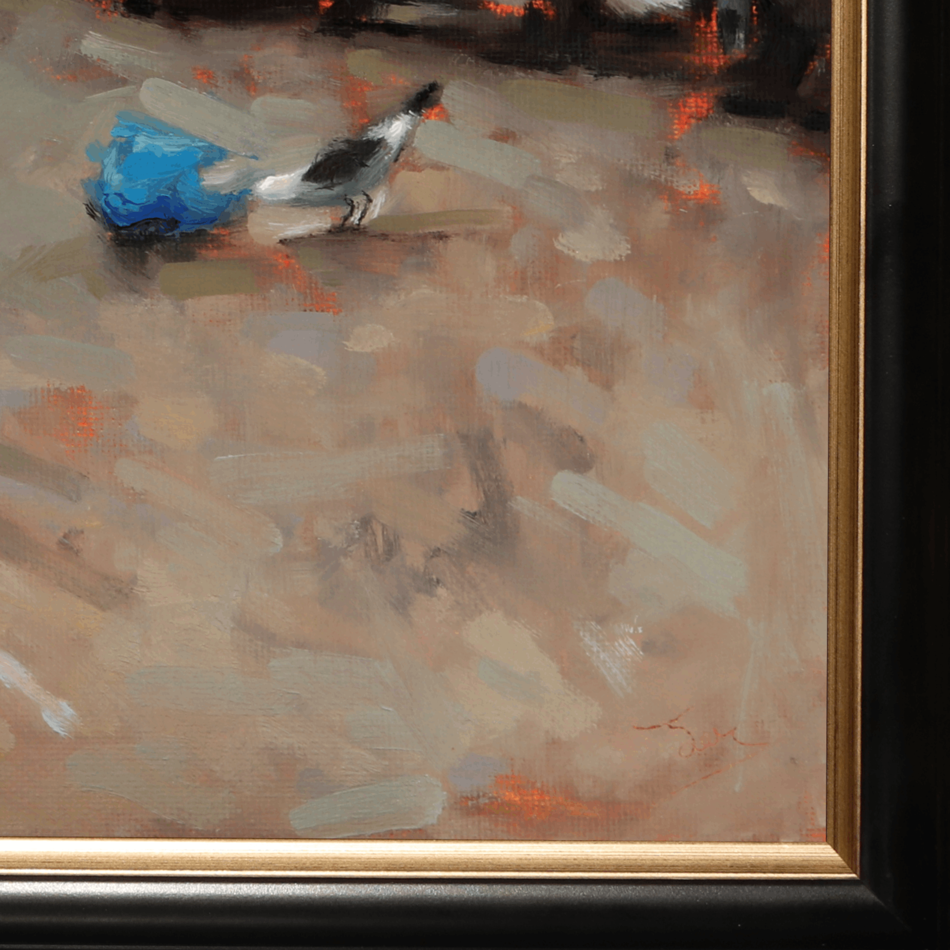 Close-up of a framed painting showing an abstract scene with a small bird and a bright blue shape against a warm beige and brown background, with visible gold and black frame details.