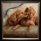 A framed oil painting depicting two golden retriever puppies resting on a cushioned sofa, with one puppy nuzzling the other. The artwork is housed in a black frame with a gold inner border.