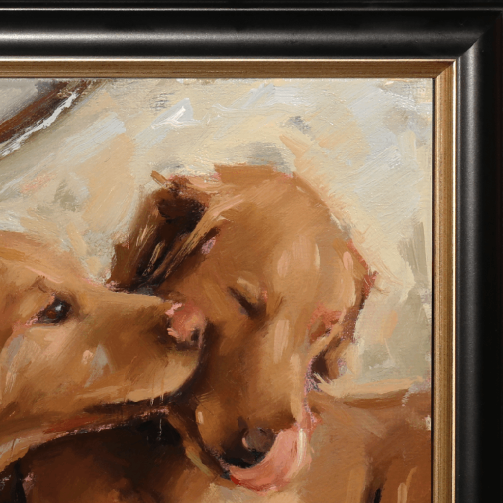 Close-up of a framed painting depicting two golden retriever dogs in warm brown and beige tones, with a black frame and gold inner trim visible.