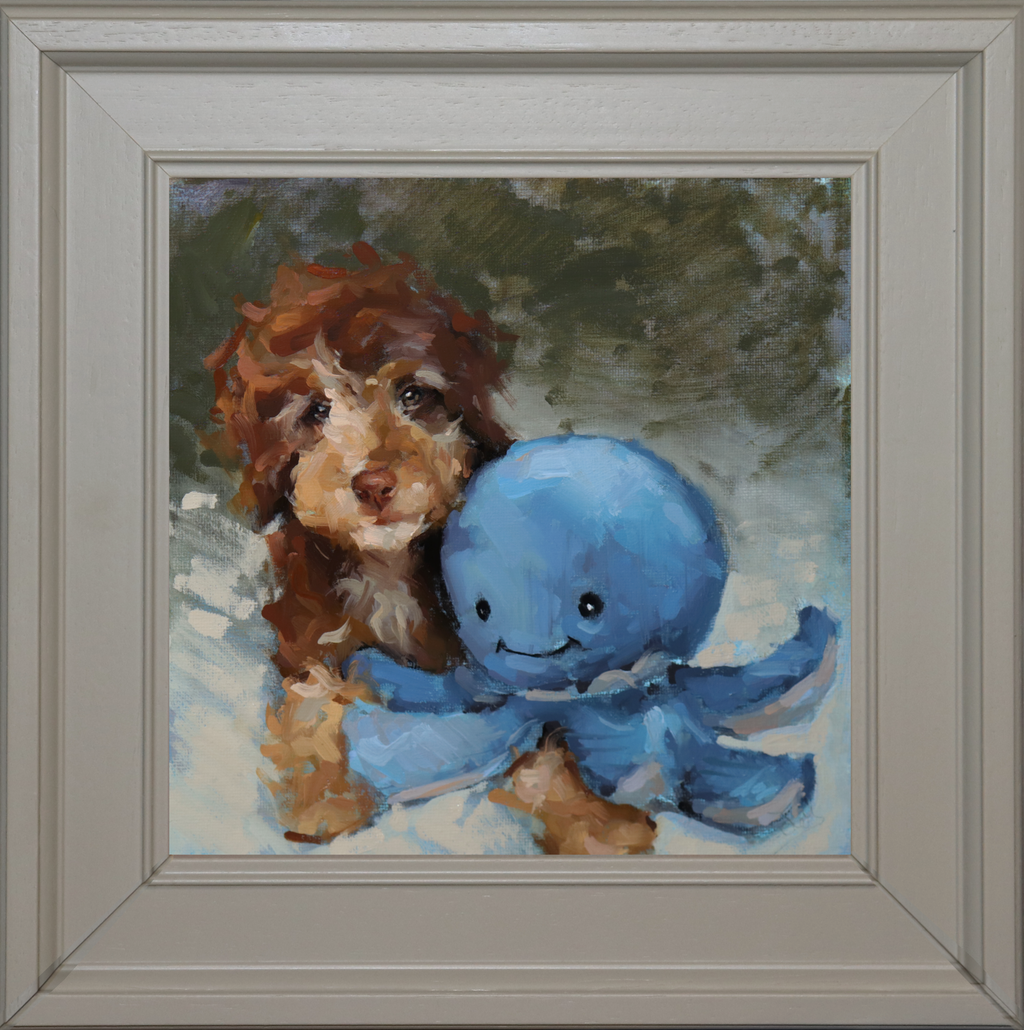 A framed custom oil painting featuring a brown and white puppy hugging a blue octopus toy, set in a light gray frame.