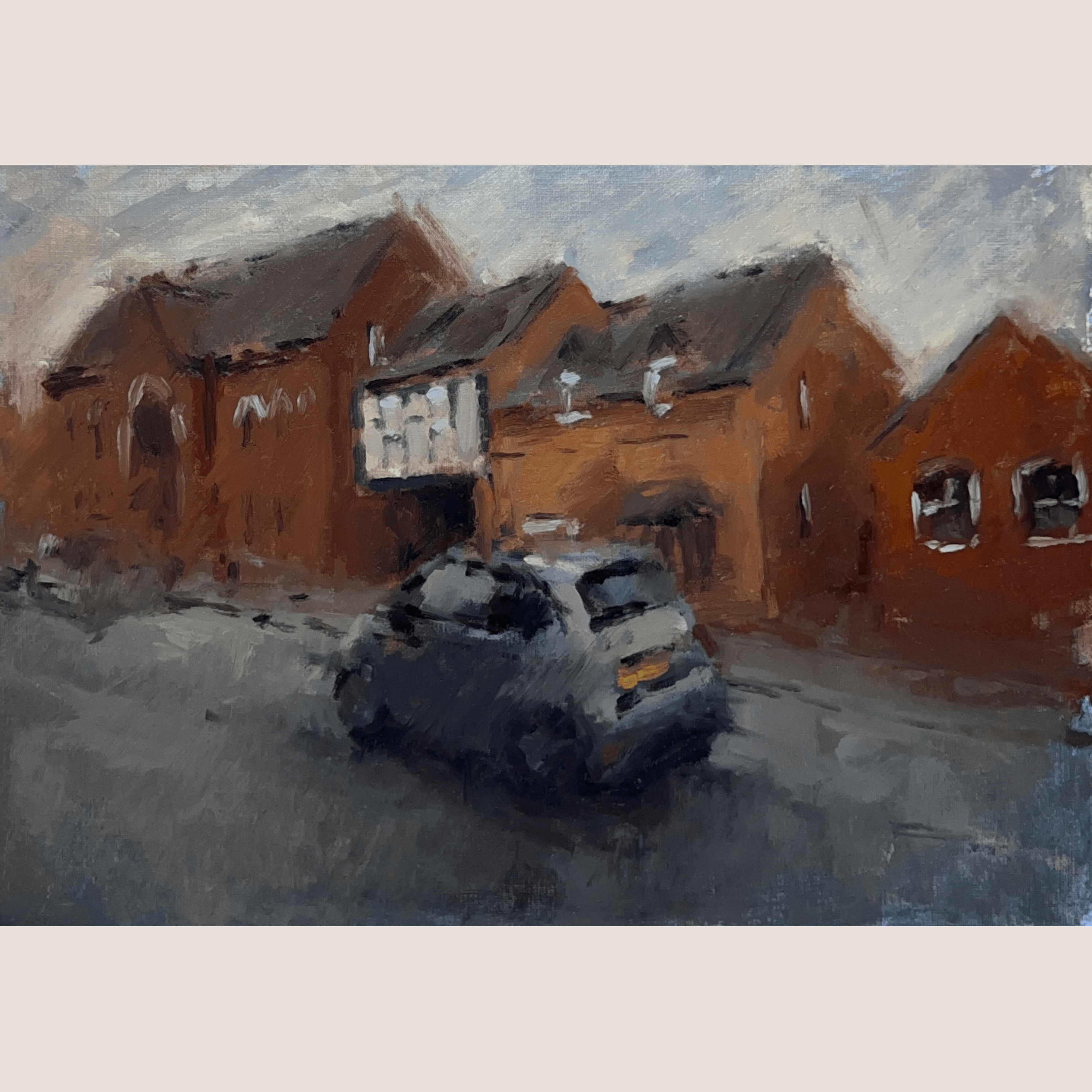 An impressionistic painting of a street scene with reddish-brown brick buildings, a dark car in the foreground, and a pale blue-gray sky, centered on a light beige background.